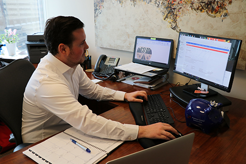 a person sitting at a table using a laptop computer